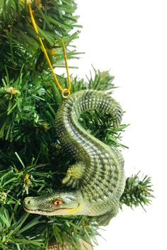 a green lizard ornament hanging from a christmas tree