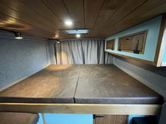 the interior of an rv with wood paneling on the walls and ceiling is shown