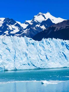 an iceberg with mountains in the background