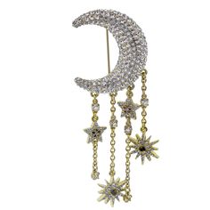 a gold and diamond crescent brooch with stars hanging from it