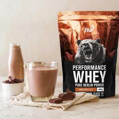 a bag of performance whey next to a glass of milk and some chocolate chips