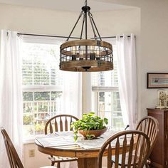 a dining room table with chairs and a potted plant on top of it in front of a window