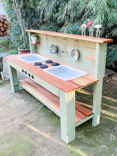 an outdoor kitchen made out of wood with two sinks and ovens on the side