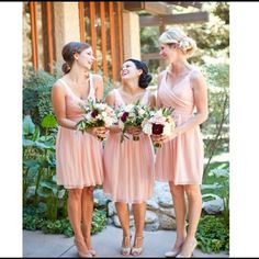 three bridesmaids in pink dresses laughing together