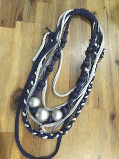 a close up of a horse's reins on a wooden floor with beads and rope