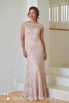 a woman in a pink dress standing on some stairs and posing for the camera with her hand on her hip