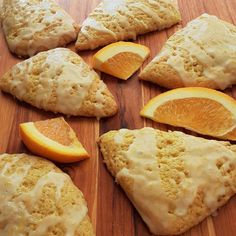 orange slices and biscuits are arranged on a cutting board with white glaze drizzled over them