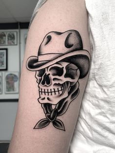 a skull with a hat and bow tie on it's arm in black ink