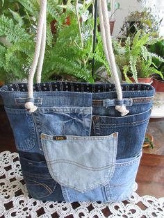 a pair of jeans hanging from a rope with plants in the background