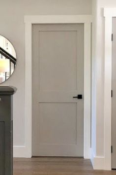 a white door and mirror in a room