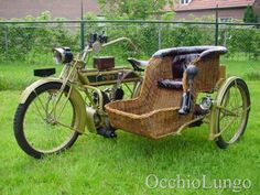 an old fashioned bicycle with a basket attached to the front is parked on some grass