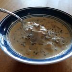 a bowl filled with soup on top of a wooden table