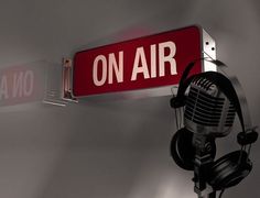 a red sign that says on air with headphones hanging from it's side