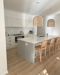 a kitchen with an island, sink and several stools next to the counter top