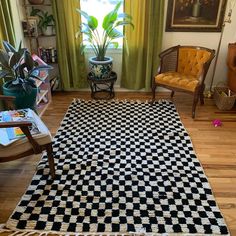 a living room filled with furniture and a checkered rug on top of a hard wood floor