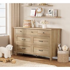 a wooden dresser sitting in a bedroom next to a window and stuffed animals on top of it