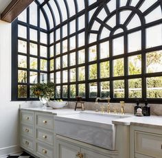 a kitchen with black and white checkered flooring, an arched window over the sink