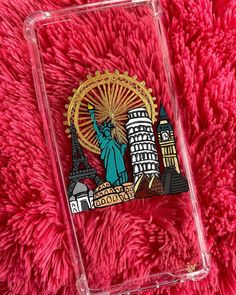 a clear case with the statue of liberty in front of a red blanket and a ferris wheel