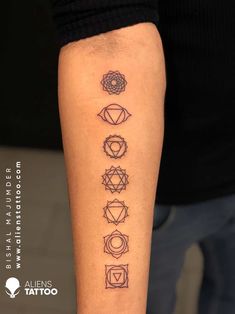 a person with a tattoo on their arm that has seven chakras in it