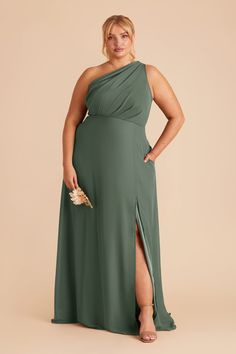 a woman in a green dress with one leg slited up and her hand on her hip