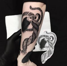 a person with a tattoo on their arm holding onto a rope that is connected to an owl