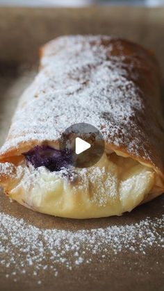 the pastry is covered with powdered sugar and has blueberries in it's center