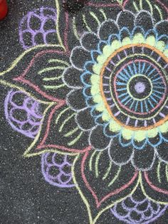 a colorful flower drawn on the ground with chalk