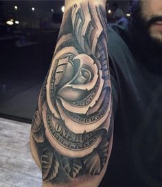 a man's arm with a rose and dollar bills tattoo on the side of his arm