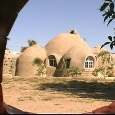 an image of a house through a hole in the ground that looks like it's made out of clay