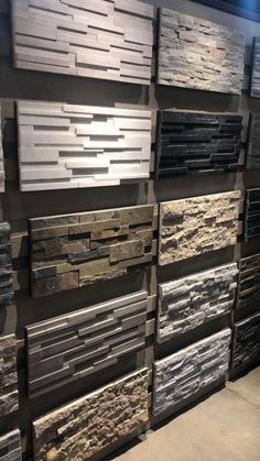 a wall with many different types of stone tiles on the walls and flooring in it