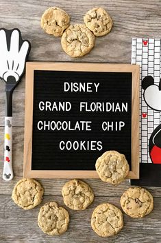 some cookies are next to a sign that says disneyland grand florigan chocolate chip cookies