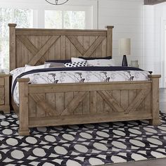 a bed with wooden headboard and foot board on top of it in a room