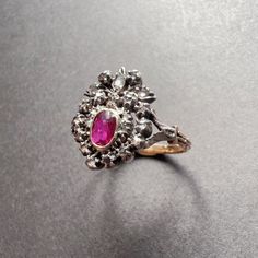 For sale a 19th century 18K gold ring featuring a crowned heart. The center of the heart is made of an oval shaped ruby of a deep purplish red color. The gem is surrounded by numerous rose cut diamonds. The gemstones are set with open backs and are firstly mounted on silver and then on 18K yellow gold. This type of ring was given in betrothal or during a wedding ceremony, as diamonds are associated with marriage, a continuing symbol of virtue and constancy in the marriage union. The deep red col Victorian Ruby Ring With Center Stone, Victorian Ruby Ring For Wedding, Victorian Ruby Ring With Rose Cut Diamonds For Wedding, Victorian Ruby Gemstone Ring For Wedding, Antique Ruby Ring With Center Stone For Wedding, Victorian Oval Ruby Ring, Heirloom Oval Rings For Valentine's Day, Valentine's Day Heirloom Oval Rings, Vintage Oval Rings With Historical Design