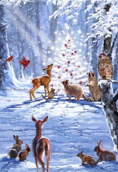 a group of animals standing in the snow next to a christmas tree with red balls on it