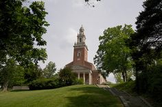 an old brick building with a steeple on top and stairs leading up to it