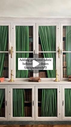 an old bookcase with green curtains on it