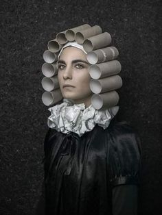 a woman with lots of cups on her head and hair in the shape of tubes