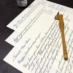 an old fashioned fountain pen sitting on top of two sheets of paper