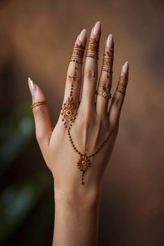 a woman's hand with gold jewelry and rings on her left wrist, holding out her right hand to the camera