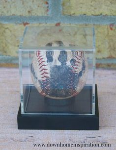 an old baseball in a glass case on a table