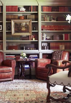 a living room filled with lots of furniture and bookshelves full of books on top of them