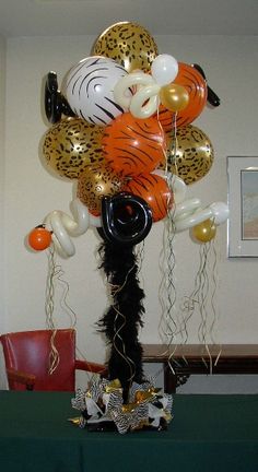 a table topped with lots of balloons in the shape of tiger and leopard heads on top of each balloon