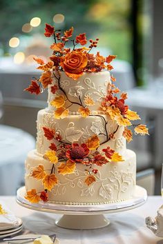 a wedding cake decorated with fall leaves and flowers