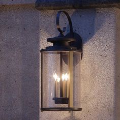 a wall mounted light on the side of a building with three lights attached to it