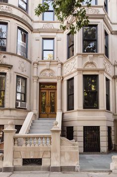 a large white building with many windows and steps leading up to the front door area