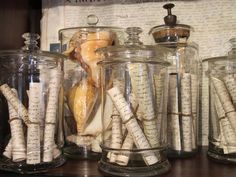 several jars filled with writing paper on top of a wooden table