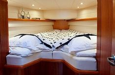 the inside of a sailboat with two beds and pillows on it's sides