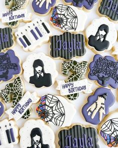 decorated cookies with the words happy halloween and images of people in black, white and purple