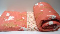 an orange and white bed spread on top of each other next to a pink pillow