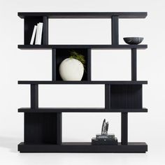 a black shelf with books, vase and other items on it in front of a white background